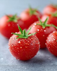 Macro Close Up Of Fresh Red Tomatoes Covered In Water Droplets On A Textured Grey Surface With Soft Natural Lighting And Shallow Depth Of Field