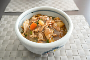 にんじんとじゃがいもが入った家庭の煮込みうどん