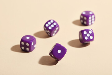 Purple game dices on beige background