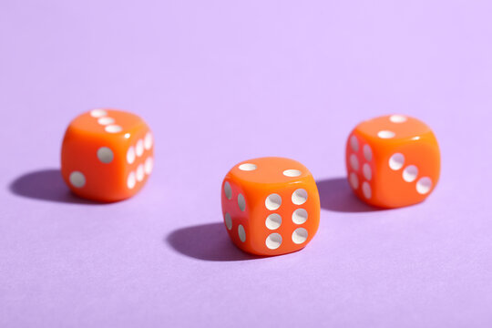 Orange game dices on purple background