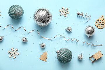 Composition with disco balls and Christmas decor on blue background, closeup