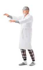 Senior male sleepwalker in pajamas on white background