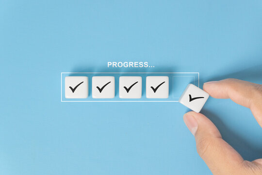 Checklist and task progress tracking concept. A hand placing the final checkmark on dice in a progress bar, task completion, productivity, goal setting, and efficient project management
