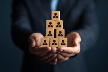 Hierarchical Hands: A close-up shot of hands tenderly cradling a meticulously arranged pyramid of wooden blocks, each adorned with a simple silhouette representing individuals, symbolizing leadership.