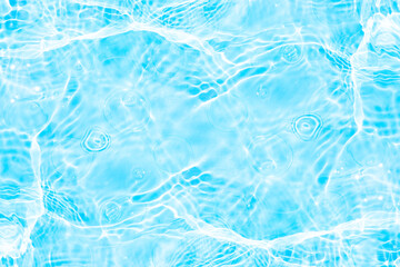 Blue water with ripples on the surface. Defocus blurred transparent blue colored clear calm water surface texture with splashes and bubbles. Water waves with shining pattern texture background.