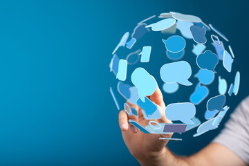 Abstract image of a hand holding a sphere made of speech bubbles, representing online communication, messaging, and information sharing.