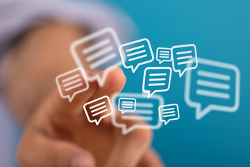 Hand interacting with digital speech bubbles representing communication, messaging, and online interaction. Conceptual image for technology and