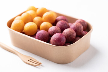 Deep fried sweet potato balls in paper box on white background, Thai street food snack