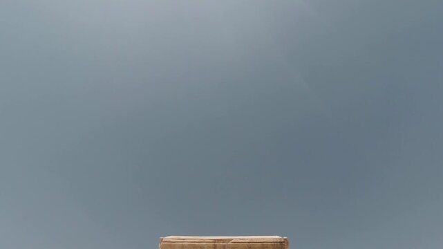 Frontal view of the Tomb of Cyrus the Great in Pasargadae, Iran&mdash;stepped limestone platform beneath a cloudless sky. Historic Achaemenid monument with a serene desert atmosphere.
