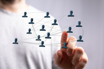 Close-up of a hand pointing at a digital network of human figures. Concept of technology, connection, and communication.