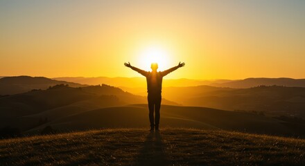 Silhouette of a Person with Open Arms Celebrating Sunrise Over Rolling Hills and Distant Mountain