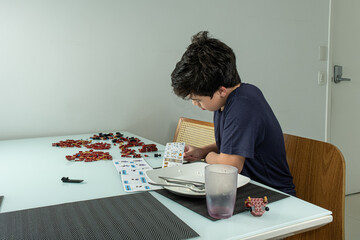 A 12 year old Brazilian boy is focused and preparing to assemble the blocks.