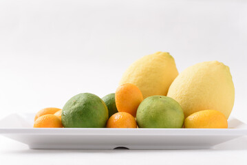 Fresh lemon, lime and kumquat on white background