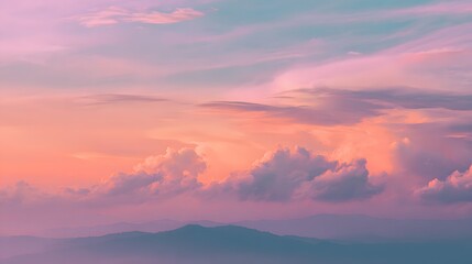 Obraz premium Vivid pastel clouds display intense coloration above layered mountain silhouettes at twilight