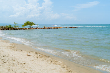 Caribbean beach with calm waves, rocky breakwater and boat in motion, Coveñas coast, Colombia © Daniel Ching