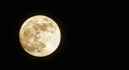 Full moon glowing in the dark night sky with visible craters