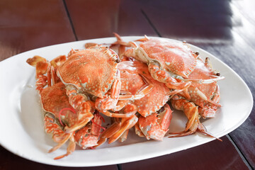 Fresh sea crabs cooked by charcoal grilling, served on the dish with Thai seafood dipping sauce at the famous local restaurant in Thailand.