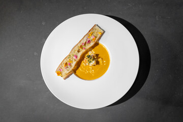 Topview Flat Lay of Garlic Bread with Creamy TomYamKung Soup on white dish in studio light, decorated with flower petal on it. Clipping Paths.
