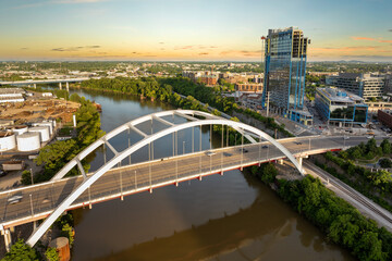 Downtown district highway bridge traffic in Nashville city, Tennessee at sunset. Brightly illuminated high skyscraper buildings in modern American midtown.