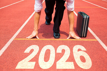Happy new year 2026 concept. Business Man preparing to run on athletics track engraved with the year 2026.