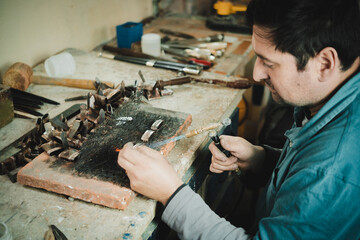 Latino man working in his workshop. Knife maker.
