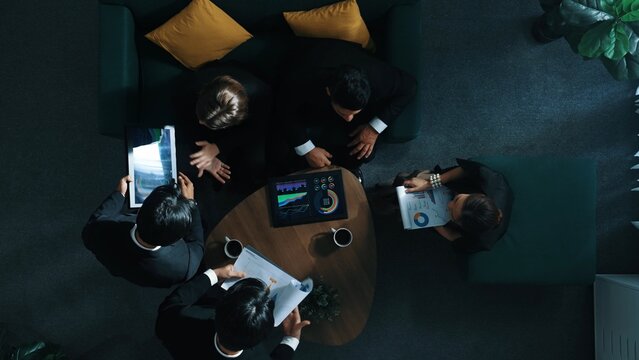 Top view of professional diverse business people analyze stock market investment data by using laptop and financial statistic graph or stock investment graph. Creative business concept. Directorate.