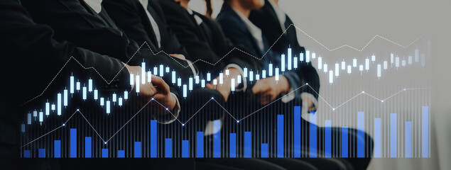 Professional Business Meeting with Financial Graphs in Background Signifying Growth and Investment...