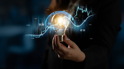 A business professional holds a light bulb symbolizing innovative ideas against a backdrop of...