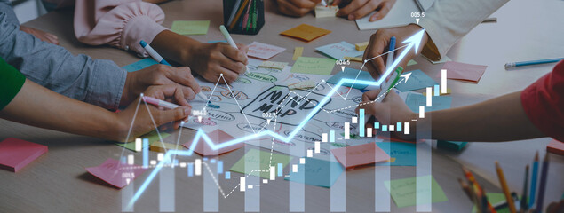 A vibrant collaborative session featuring diverse hands engaged in brainstorming using a mind map,...