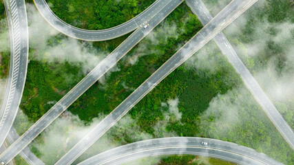 Aerial view of dark green forest road and white electric car Natural landscape and elevated roads...