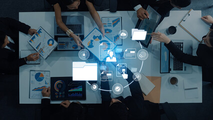 Diverse group of professionals engaged in a collaborative meeting, analyzing digital data and charts displayed on screens in a modern office environment. Trope