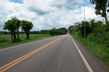 Asphalt road steep path through small hills in rural area.