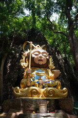 The statue of Sun Wukong in Chibi cartoon style is located between a small mountain gorge.