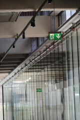 Emergency exit sign in a modern glass corridor