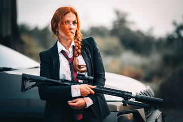 Redhead woman in a suit with a rifle. Special agent.