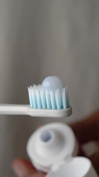 Brushing teeth with toothpaste on a toothbrush