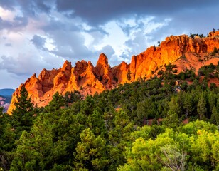Scenic landscape featuring red rock cliffs, lush trees, and a cloudy sky
