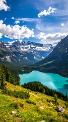 Scenic landscape with alpine lake, mountains, and bright blue sky