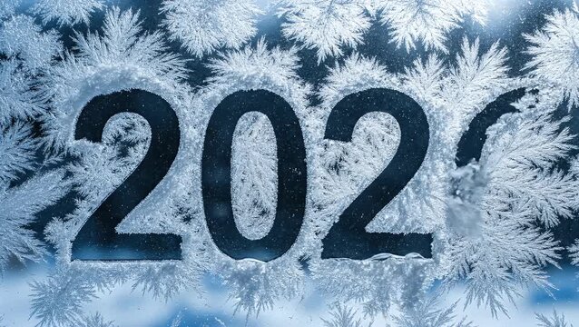 The numbers 202 drawn on a frosty window pane surrounded by beautiful ice crystal patterns for a festive new year concept