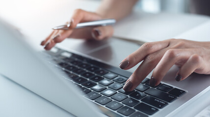 Close up, woman hand typing on laptop computer keyboard. Business woman online working on laptop computer, surfing the internet, searching the information at home office, e-learning