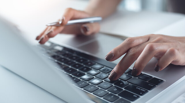 Close up, woman hand typing on laptop computer keyboard. Business woman online working on laptop computer, surfing the internet, searching the information at home office, e-learning - Powered by Adobe