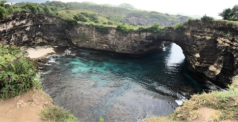 Natural Coastal Arch with Clear Blue Water and Rocky Cliffs