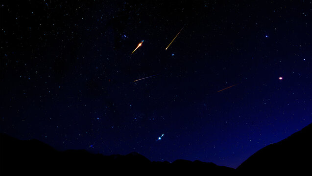 Meteor shower streaks across a dark starry night sky above silhouetted mountains meteors shooting stars