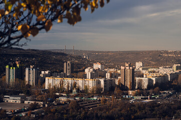 Urban residential cityscape with high-rise buildings surrounded by autumn foliage and distant hills...