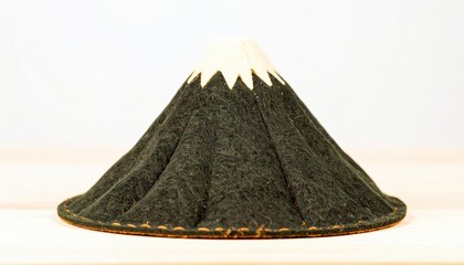 A dark, cone-shaped hat with a white top, resembling a stylized mountain.