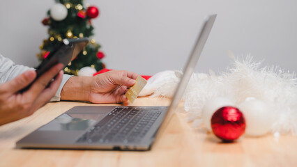 Man Shopping Online with Credit Card and Laptop for Christmas