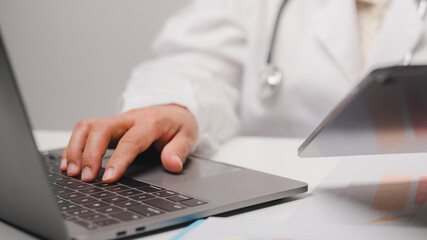 Doctor Working Laptop and Tablet in Medical Office
