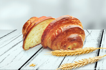 Freshly Baked Golden Croissant Sliced ​​in Half with Wheat Stalks on a Wooden Table