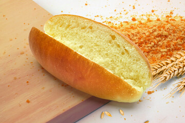 Freshly Baked Soft Bread Roll Hot Dog Bun Sliced with Wheat Stalks and Crumbs on Wooden Board