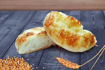 Freshly Baked Cheese Bread Rolls with Wheat on Wooden Table